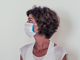 woman protecting from corona virus covid-19 wearing on a medical face mask looking to the side on...
