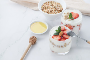 a cup of yogurt and strawberries on the table
