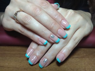 The manicurist excellently made her work a beautiful manicure with a polish gel on her hands and the client is happy