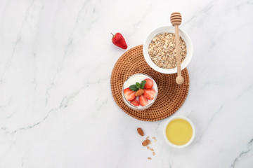 a cup of yogurt and strawberries on the table
