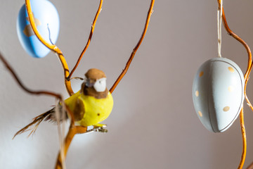 Osterdekoration Strauch mit Ästen, Vogel und bunten Ostereiern