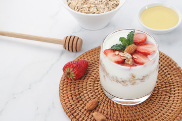 a cup of yogurt and strawberries on the table

