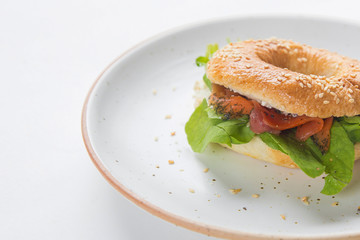  Bagel sandwich with cream cheese, salmon and arugula isoalated on white background