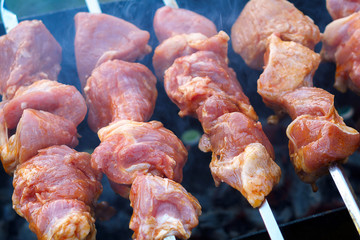 raw meat is grilled on coals. meat shashlyk shish kebab pork meat grilling on metal skewer. close up. soft focus