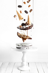 Flying chocolate cake with chocolate caramel cream, decorated with cookies, waffles, caramel, sweets and chocolate GLAZE