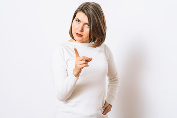 Fototapeta premium studio portrait of a beautiful girl pointing to the camera