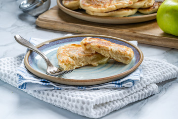 Fluffy homemade pancakes with apple dusted with icing sugar