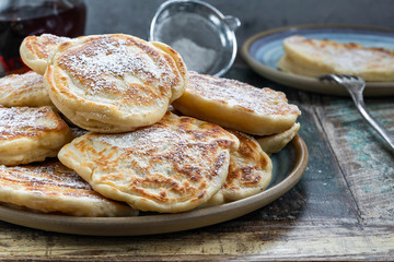 Fluffy homemade pancakes with apple dusted with icing sugar