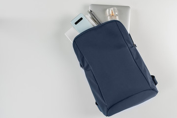 Female blue backpack with notebook, smartphone and perfume . Top view, copy space. Business trip and telework concept