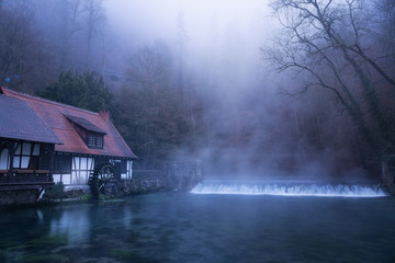 Der Blautopf in Blaubeueren an einem nebligen Morgen.