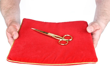 Golden scissors on a red pillow