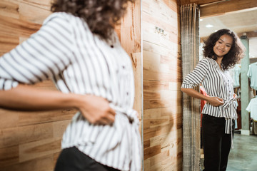 Beautiful woman wearing nice clothes, posing on fashion shop boutique fitting room