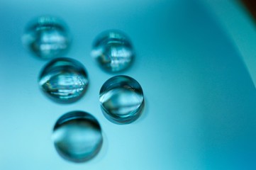 Drops of water on a compasc disc with blue filter in macro view