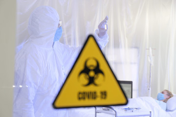 Doctor in biohazard suit and with vaccine in contagious isolation ward. Concept of Coronavirus...