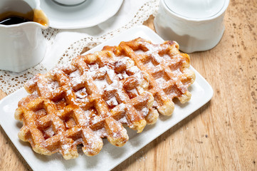 Tasty Belgian dessert, Brussels waffles with syrup and white sugar powder