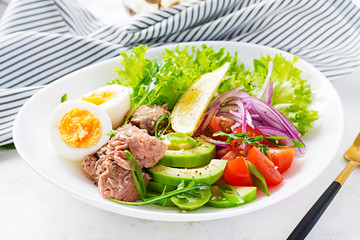 Healthy food. Tuna fish salad with eggs, lettuce, cherry tomatoes, avocado and red onions.  French cuisine.