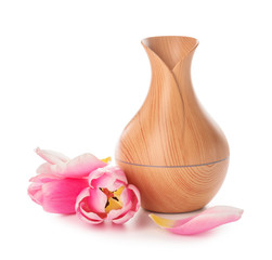 Aroma oil diffuser and flowers on white background