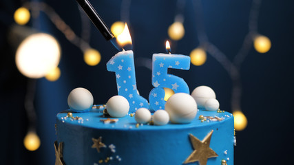 Birthday cake number 15 stars sky and moon concept, blue candle is fire by lighter. Copy space on...