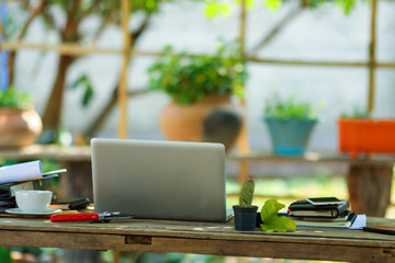 Laptop on wood table for working online at home in the garden.