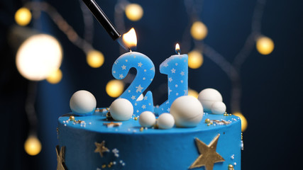 Birthday cake number 21 stars sky and moon concept, blue candle is fire by lighter. Copy space on...