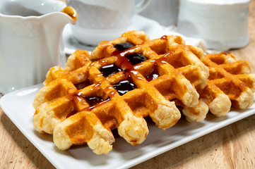 Tasty Belgian dessert, homemade Brussels sugar waffles with dark syrup