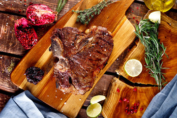 Grilled T-bone barbecue steak with fresh rosemary on a chopping Board