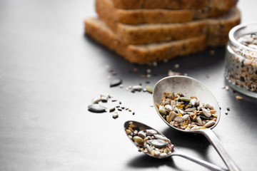 Healthy bread slices on dark background with mix of seeds.