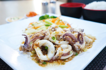 Squid fried with garlic on white plate