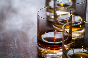Tasting of flight of Scotch whisky from tumbler glasses in old Edinburgh pub,  Scotland, UK