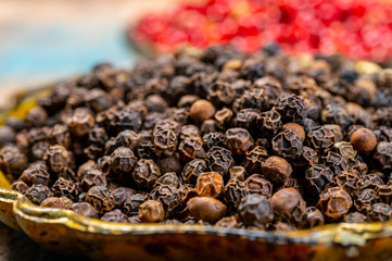 Bowl with dried black and red round peppers condiment