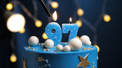 Birthday cake number 97 stars sky and moon concept, blue candle is fire by lighter. Copy space on...