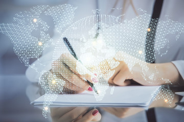 International business hologram over hands taking notes background. Concept of success. Multi...
