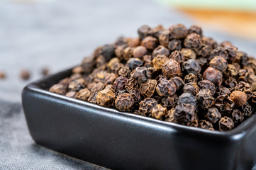 Bowl with dried black round peppers condiment