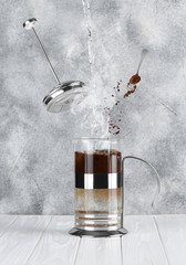 Process of making coffee. French press on a gray concrete background. Food and drink levitation...