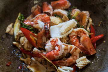 Selective focus of fried stir spicy sea food in pan, Pad Cha Talay Sea Food, Thai food. Close up