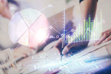 A woman hands writing information about stock market in notepad. Forex chart holograms in front. Concept of research. Double exposure