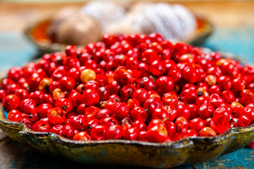 Bowl with dried red round peppers and nutmegs