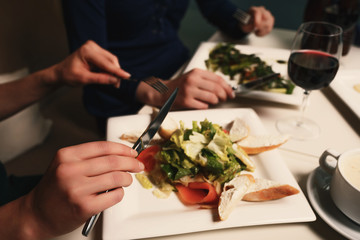 Two young successful women are having dinner in a restaurant and talking
