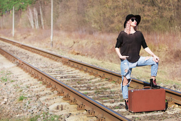 Young traveling woman with a suitcase on the railway	