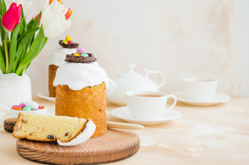 Easter composition. Easter Cake - Russian and Ukrainian Traditional Kulich with easter eggs on a light stone background. Paska Easter Bread. Selective focus. Horizontal orientation. Copy space.