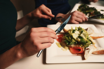 Two young successful women are having dinner in a restaurant and talking