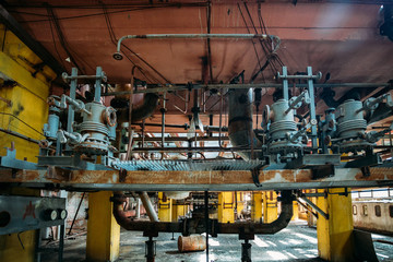 Old rusty Industrial tanks connected by pipes connected with valves in abandoned chemical factory