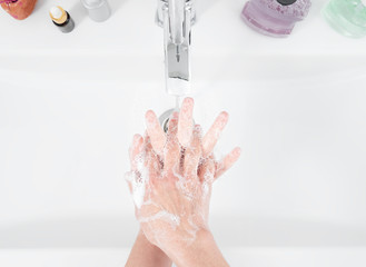 Woman use soap and washing hands under the water tap. Hygiene concept, top view, healthcare....