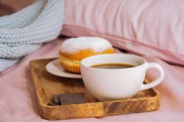 Morning breakfast in bed with fresh and hot coffee, a doughnut in powdered sugar and three slices...