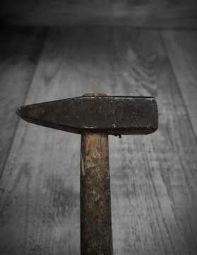 Old hammer on wooden floor background