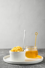 National food cuisine of the Middle East. Sweet dessert made of dough and honey chak-chak in a ceramic white bowl and a teaspoon on a gray concrete table. Vertical orientation, copy space.