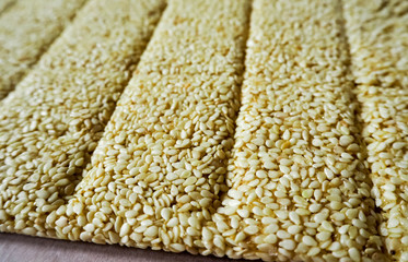 White sesame seeds with honey and sugar as a solid background in the process of making gluten free cookies