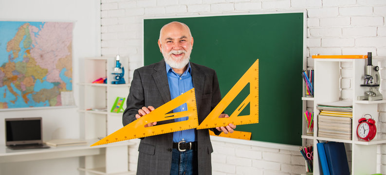 solve mathematical problems. mature man teacher use math triangle tool. bearded tutor man at blackboard. back to school. Math science concept with school lesson items. Mathematics at chalkboard