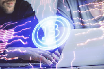 Crypto currency theme hologram with businessman working on computer on background. Concept of blockchain. Double exposure.