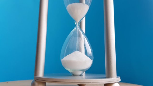 Elegant hourglass on a blue background. Concept-business time money, education, time is running out, time management, time resource, fulltime, deadline